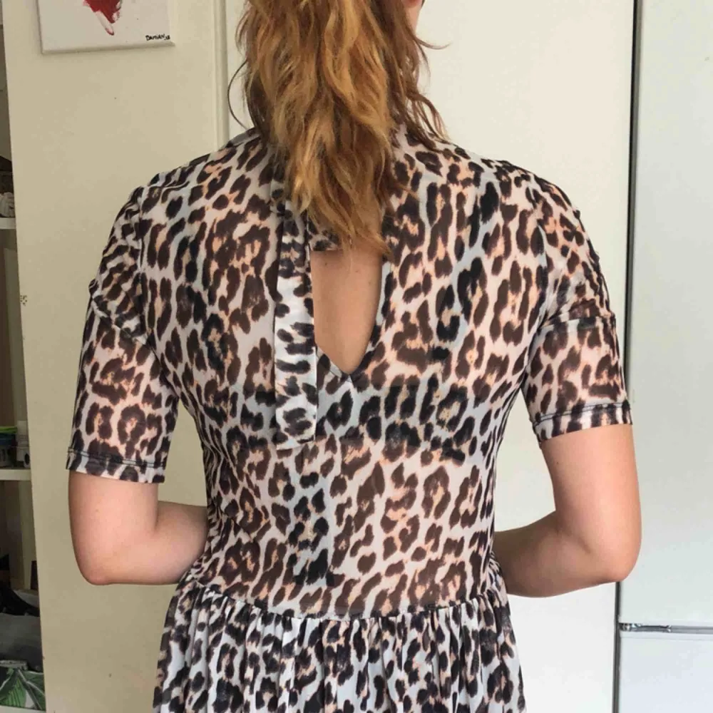 Leopardmönstrad klänning som slutar strax nedanför knät, hög krage med knytning i nacken. . Klänningar.