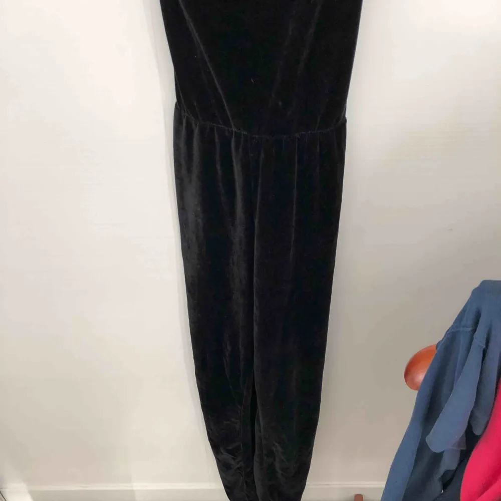 Jumpsuit från Bikbok storlek XS. Tyget är svart valvet. Resor i midjan vilket gör att den sitter fint. Långa i benen. Omlottsnörning i ryggen.. Klänningar.