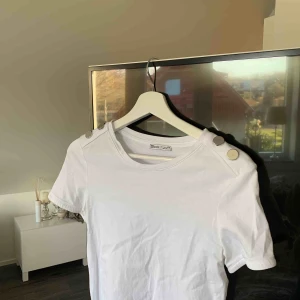  - Snygg vit T-shirt med silvriga detaljer på axlarna. 