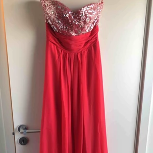  - Helt ny balklänning i str 34. Hjärtformad urringning och korsad rygg med paljetter på både fram och baksida. Aldrig använd!  