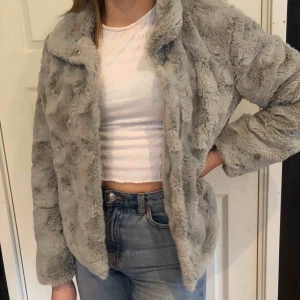  - En pälsjacka i grått som är väldigt bekväm och har ändats använt 1 gång. Passar bra till allt. 