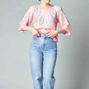 Paljettdröm - Ljusrosa paljettopp med pärlapplikationer och axelvaddar. Boxig form och härligt fall. Mäter 54 cm mitt fram. 48 cm ärmhål till ärmhål. Frakt exklusive. 