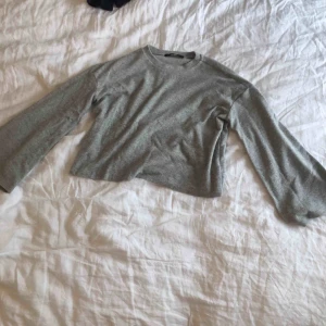  - Grå tröja med flare ärmar. En favorit som är perfekt på sommarkvällar med dess mjuka fleecetyg. 