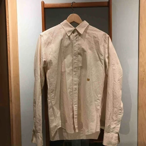  - Gul och vitrandig skjorta från Acne Studios. Använd ett fåtal gånger och är i bra skick. 