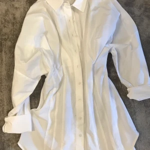 Skjort-klänning  - Säljer en skjort-klänning från Zara köpt för 359kr och säljs för 280kr ink frakt. Oanvänd storlek M men passar även S. Prislappen är kvar. 