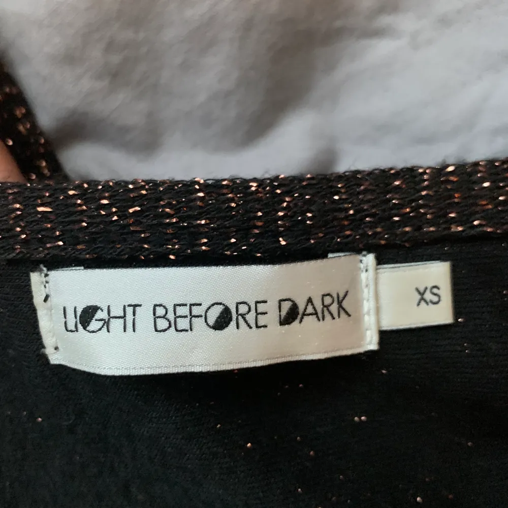 Croppat linne i svart med guldglittrigtråd. Från Urban outfitters märke light before dark. Superfint!💫. Toppar.
