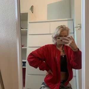 Röd bomberjacka - Röd bomberjacka från märket Stay köpt på Carlings. Ganska väl använd men fortfarande i mycket gott skick. Lagomt tjock, passar till våren/hösten eller sommarkvällar. Unisex modell. 