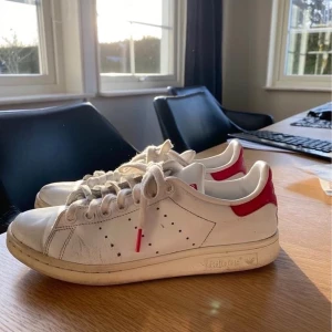 Adidas Stan Smith skor - Säljer ett par Stan Smith skor från Adidas med rött märke.  De är i använt skick, därav det billiga  priset Storlek: 39 1/3