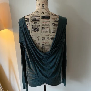 Fin grön topp med draperad rygg - Cool topp med låg draperad rygg. Vackert glansigt tyg i en grågrön färg (bäst visad på bild 3).