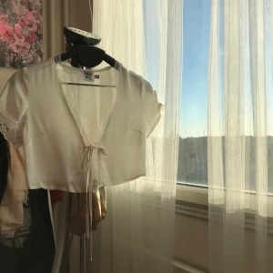 Vit satintopp från Princess Polly - Gräddvit topp i Satin med spets från Princess Polly i strlk 34. Aldrig använd ute, men ett väldigt gulligt alternativ till vit t-shirt. Kontakta mig för fler bilder och för köp. Till priset tillkommer en fraktkostnad på 22 kr!