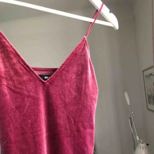  - Fin rosa(rosalila?) klänning/fodral med tunna axelband. I sammet (syntet). Från Bikbok. Storlek XS.