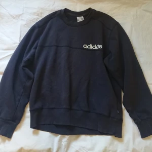 Adidas crewneck  - Superfin Adidastjocktröja i mörkblått. Köpt secondhand med i bra skick, dock snyggt blekt av tvätt. Passar storlek xs-l beroende på passform jag på bilden är 165 lång och har vanligen storlek s/m