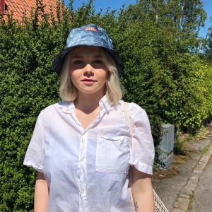 Buckethat i mörk batik - En buckathat i mörk batik med en ”Dagens industri”-logga framtill.