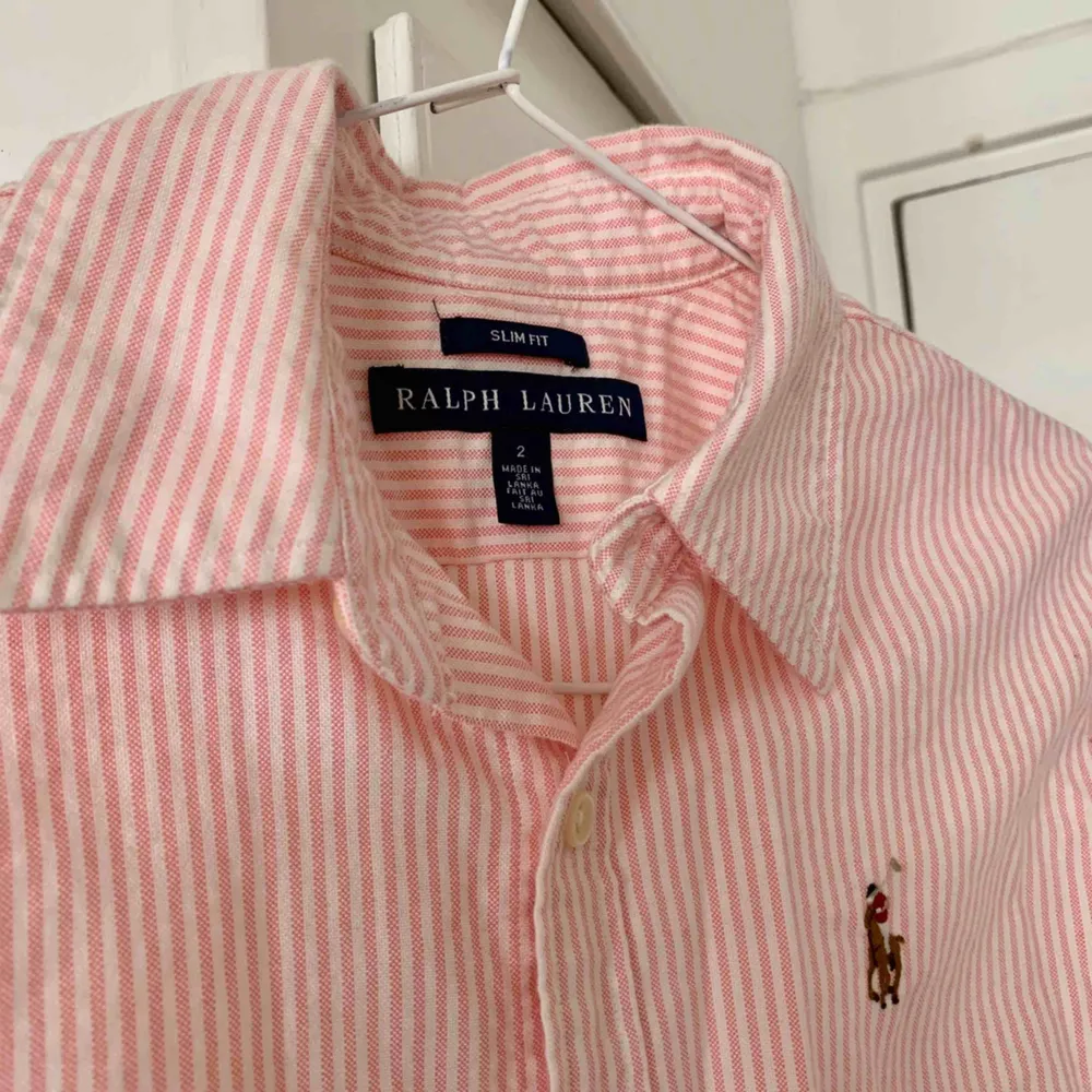 Vit- och rosarandig skjorta från Ralph Lauren. Figursydd Använd endast ett fåtal gånger, i mycket fint skick! Storlek US 2/XS. Möts upp i Stockholm eller så står köparen för frakt. 🌸. Skjortor.