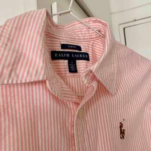Vit- och rosarandig skjorta från Ralph Lauren. Figursydd Använd endast ett fåtal gånger, i mycket fint skick! Storlek US 2/XS. Möts upp i Stockholm eller så står köparen för frakt. 🌸