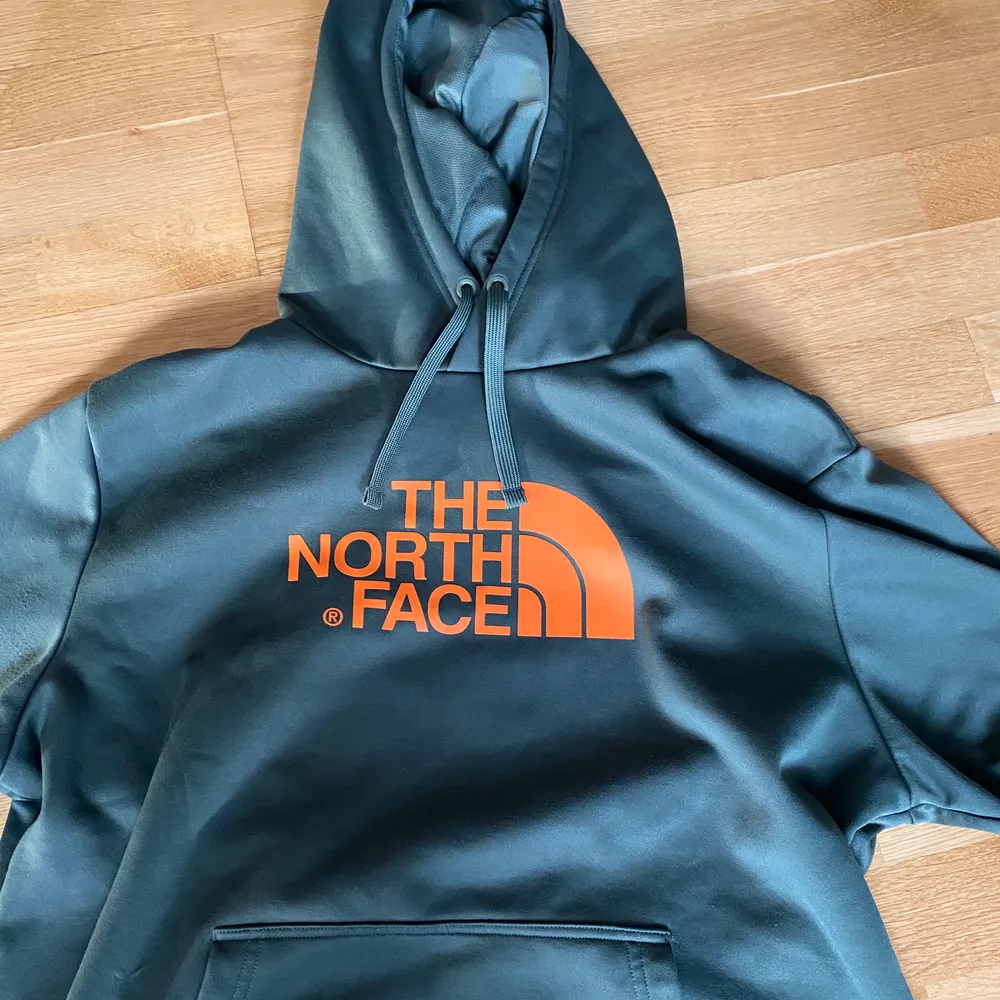 Grön hoodie från the north face med oranget tryck. Den är knappt använd, den är så gott som ny! Sitter mer som en L/M. Hoodies.