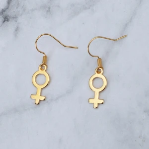Örhänge kvinnosymbol guld  - Fina guldfärgade örhängen med kvinnosymbolen. Finns även som silverfärgade och roséguldfärgade. Nickelfria. 
