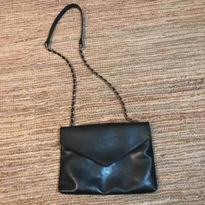  - Svart kuvertväska från Nelly. Nyskick