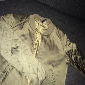  - tunn bomberjacka från H&M i grön färg och guldig kedja
