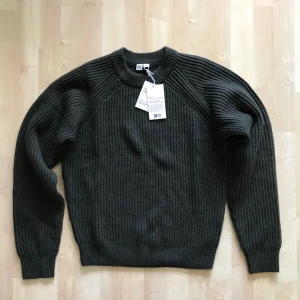  - Brand New with tags, Uniqlo U stickat/knitwear jumper in collaboration with famous french designer Christopher Lemaire. Limited edition in lambswool material.  Size is XS but really fits an S size for someone between 170cm to 180cm.   Dark military green in colour.  Bought in Tokyo, Japan.