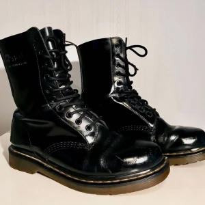  - Klassiska 10 håls Dr. Martens kängor i storlek 40 säljes för 150kr, frakt tillkommer. Liten defekt med slitning på vänstra skon fram, se bild 3. Betalning sker via swish.