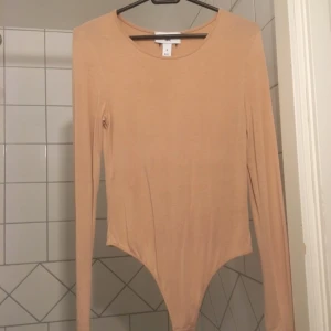  - beige/nude body från Rebecca Stella. knäppning nedtill, en av de tre knapparna har gått sönder men det är inget man märker av när man använder den. fint skick i övrigt! 