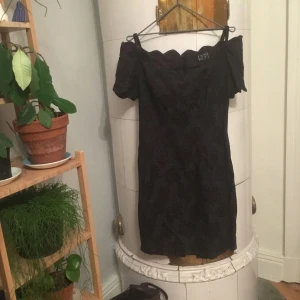  - Den lilla svarta, ringning som sitter på axlarna mönstrad i svart blommönster. Dragkedja baktill. Vintage