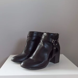  - Svarta boots i ”läder” med fina detaljer och cut-outs • Helt ok skick men dessvärre ett antal repor och blemmor (priset kan därför diskuteras) 