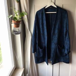 Kimonoinspirerad blå, blommig kavaj i mjukt tyg. Sömmen är lite trasig i nedre höger hörn, inget märkbart! 