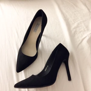  - Svart pumps i mockaimitation från NLY shoes i storlek 38. Jag skulle säga att de passar någon med storlek 37/38. Aldrig använda, bara testade. Klackhöjd 10cm