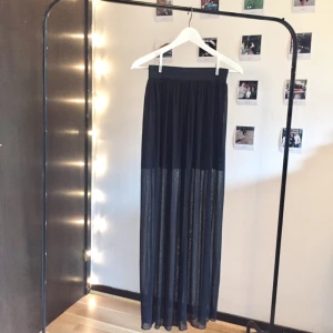  - Trendig svart kjol med lager. En kortare, tjockare underkjol och genomskinlig lång överkjol. Stretch i magen. Jättehärlig i vinden. Mötes upp i Stockholm eller fraktas. 