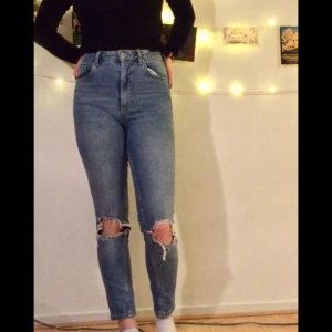  - Högmidjade jeans i modellen Leah från Gina med hål vid knäna. Använda men fint skick! Skickas mot fraktkostnad  eller möts upp i Linköping 💘