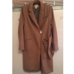  - Kanonsnygg beige kappa med skärp. Varm jacka med dragkedja på framsidan till vänster. Strl 36/38