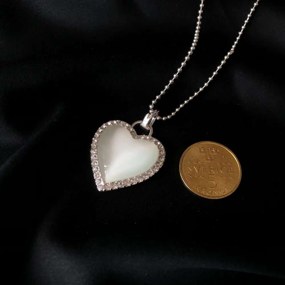 Vacker silvrig hjärt halsband med diamanter runt om🤩💫 Stilit att ha på sig med vilken outfit som helst✨👍🏻 bild två visar storleken jämfört med 5 krona. HELT NY OCH OANVÄND💫✨ frakt tillkommer på 11kr🤩. Accessoarer.