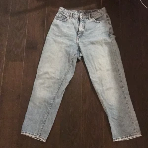 Monki Mom Jeans strl 25  - Ett par Monki high ankle Mom jeans som är ljusblåa och storlek 25 i midjan. Dem är använda men väldigt sparsamt eftersom de inte alls passade och de har legat i min garderob ett tag nu! Nypriset var 399 kr och de är väldigt bra kvalitet, inga fläckar eller liknande och skriv till mig för att ge bud!