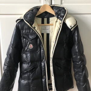 Dunjacka från Moncler - En varm dunjacka från Moncler i storlek 2, motsvarar en S. Passar perfekt nu till vintern!   Jackan är lite smutsig i kragen och en knapp är utbytt, inget som syns dock. Annars är jackan i bra skick utan några skador.   Har tyvärr inget kvitto då den köptes begagnad för 3-4 år sen. Kan skicka bild på jackans serienummer om man vill se äkthet, eller bara ha fler bilder! 
