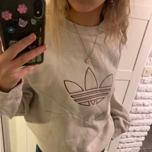 Snygg adidaströja i ljusbeige med vinröd/lila logga i storlek 36 men skulle säga att den är något oversize för att endast ha storlek S