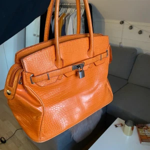 Orange väska - Säljer min orangea vintage väska köpt på humana i Stockholm!🥰💘 super fin och bra skick, väldigt rymlig! Den har dock en liten typ fläck på baksidan, men denna fanns när jag köpte den men tyckte inte den va så märkbar då den är såpass liten och på baksidan💘 (syns på bild 2)