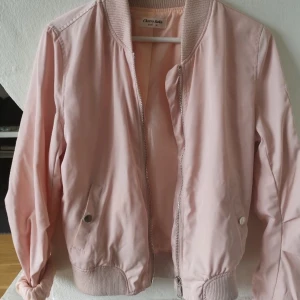 Ljusrosa bomberjacka - En fin ljusrosa bomberjacka som är i nyskick, den har inga slitningar. Den är tunnare så den är väldigt skön och luftig att bara slänga på sig! En utav mina favorit jackor när jag var yngre. Ny pris 399kr