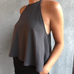 Kortare top från ginatricot  - En kort topp som är hög i halsen. Knäpps med en knapp i nacken. Snygg till fest och vardags. 