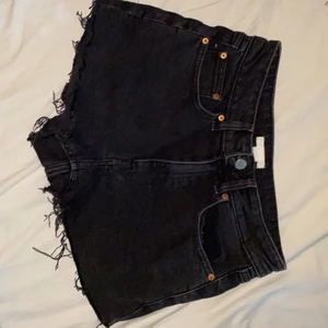 Jeansshorts  - Svart/gråa (urtvättad svart imitation) jeansshorts med rå kant. Hög midja och sitter fint, ger fina former