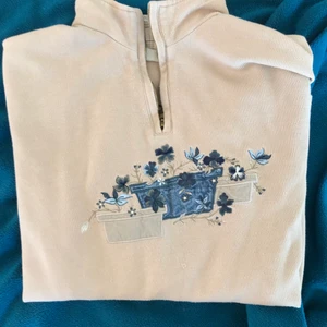 Tröja - Beige långärmad tröja med blåa broderade blommor. Sitter lite oversized på mig som är en S/M.