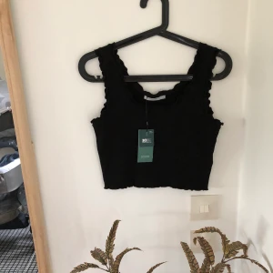 Topp VeroModa  - Svart croppad topp från VeroModa i storlek M. Ny med tagg. Nypris 130kr,  mitt pris 100kr inkl porto 