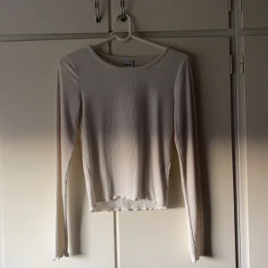 Gina Tricot tröja - En vit tröja från Gina Tricot med små volanger i armarna och längst ner på tröjan. Säljer då den inte kommer till användning.