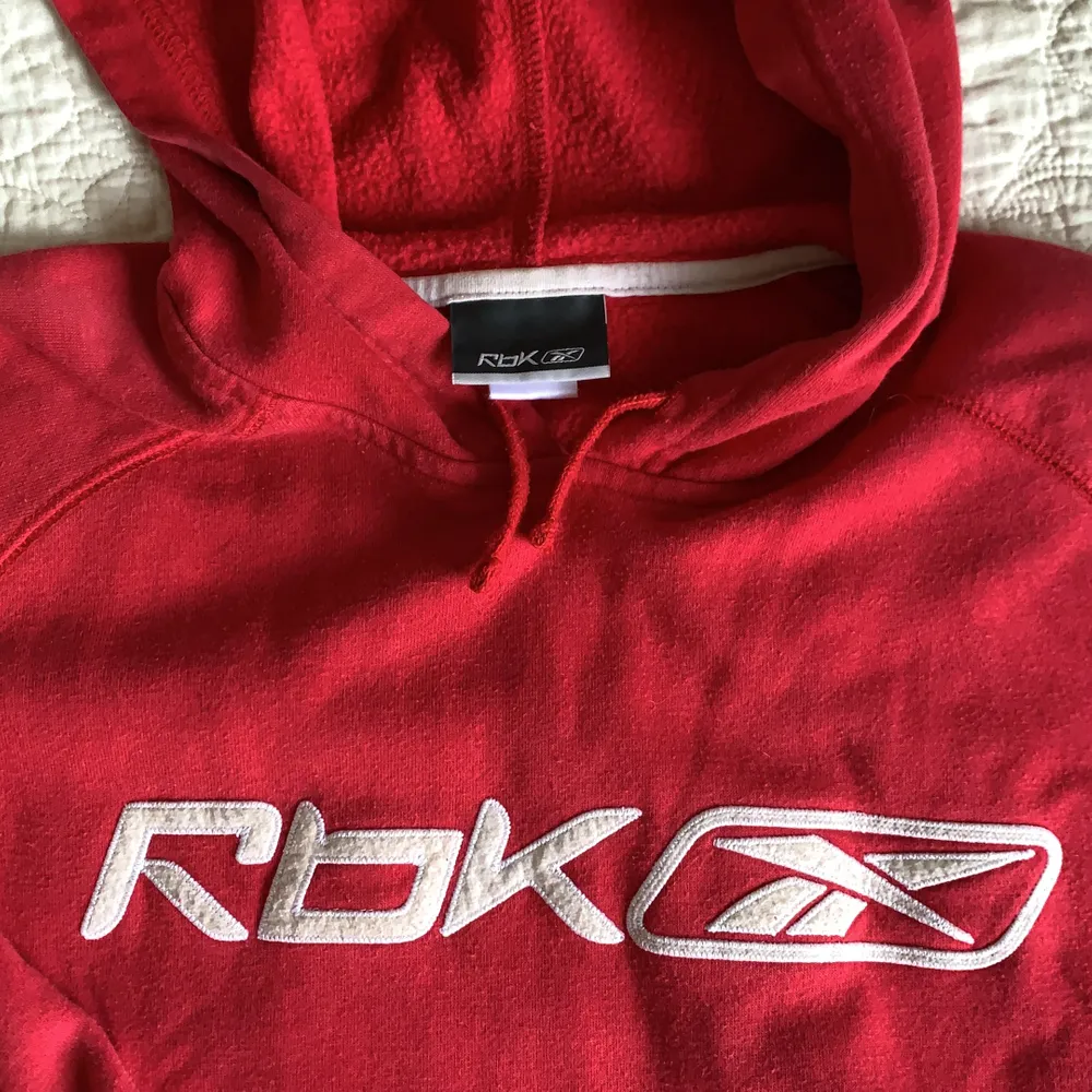En röd lite urtvättad (på ett bra sätt) hoodie från Reebok. Jag har storlek xs och vill säga att den sitter prefekt på mig! . Tröjor & Koftor.