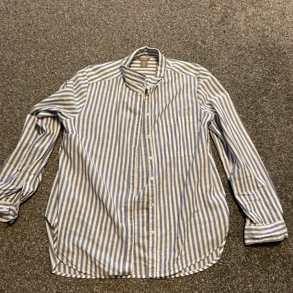 En fin skjorta från Lindex med ljusblåa ränder. Enbart använd någon enstaka gång och är därför som i nytt skick. Säljer för att den bara hängt i garderoben och aldrig kommer till användning. Nypris: 399kr. Köparen står för frakt. . Skjortor.