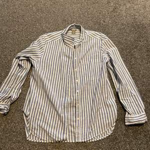 En fin skjorta från Lindex med ljusblåa ränder. Enbart använd någon enstaka gång och är därför som i nytt skick. Säljer för att den bara hängt i garderoben och aldrig kommer till användning. Nypris: 399kr. Köparen står för frakt. 