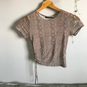 • Mesh-topp med ormmönster • - Croptop med ormskinnsmönster från Glassons, kortärmad och med dragsko på sidan vilket gör att man kan välja lite vilken längd man vill ha. Knappt använd och i mycket fint skick, perfekt med en snygg bh under! Frakt tillkommer✨