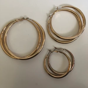 Guld örhängen, ringar - Här har vi 3 fina guld örhängen/ringar i olika storlekar. Dom är köpta på H&M för några månader sen och använts ca 1 gång vid provning😊 20kr/st och 45kr för alla 3