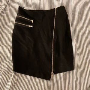 Kjol med dragkedje detaljer - Svart snygg kjol med coola detaljer, köparen står för ev frakt 